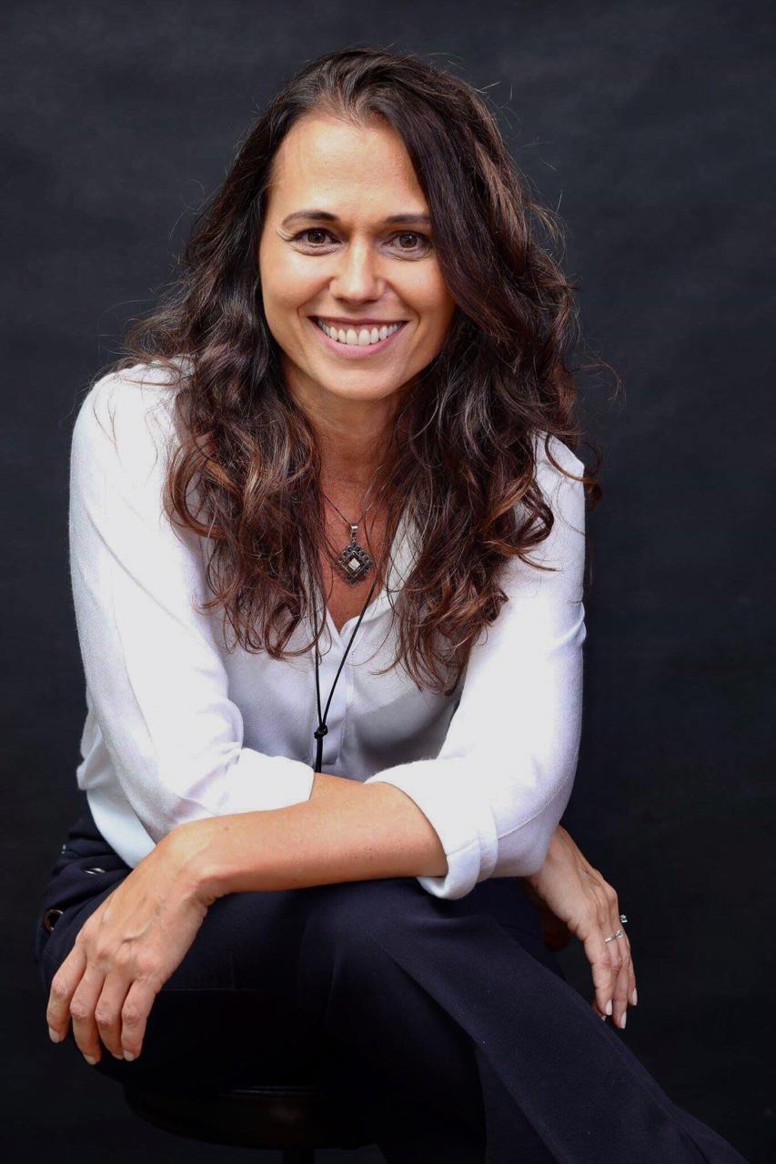 Ângela Mestriner, de blusa branca, sorrindo